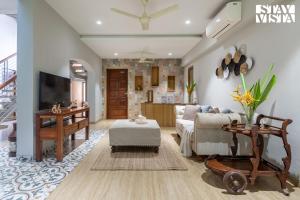a living room with a couch and a tv at StayVista at Willow Cove with AC, WiFi in Jambhulpāda