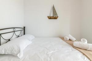 a bed with white sheets and a christmas tree on the wall at Harmony Apartment 2 in Agios Sostis +9 photos