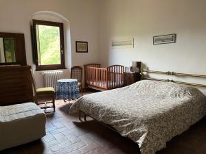 a bedroom with a bed and a chair and a window at Ca' Vamperti in Cigliano