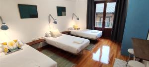 a room with two beds and a couch at El Tercer Piso in Puente la Reina