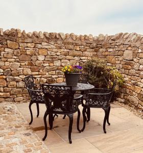 a table with two chairs and a pot of flowers at The Forge, Newly Converted Barn in Carnforth