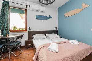 a bedroom with a bed and a desk and a window at Lazurowy Dwór - Przystań Latarnika Grand Apartments in Sztutowo