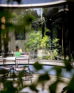 eine Terrasse mit Stühlen und Pflanzen in einem Gebäude in der Unterkunft Greulich Design & Boutique Hotel in Zürich