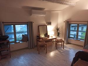 a living room with a desk and a mirror at Entre vignes et pierres in Vaison-la-Romaine