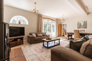 a living room with a couch and a television at Stylish Coach House Retreat in Wymondham