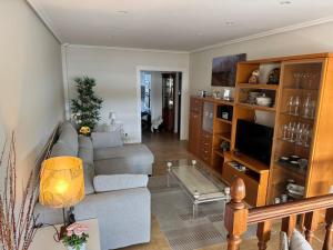 a living room with a couch and a tv at Playa de los Locos con Garaje Recién Reformado!! in Suances