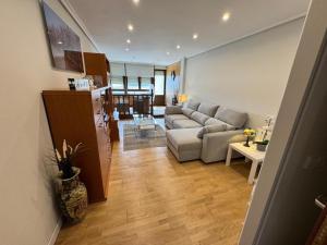 a living room with a couch and a kitchen at Playa de los Locos con Garaje Recién Reformado!! in Suances