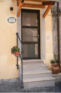 a front door of a house with stairs and flowers at Antica Locanda in Monterosi