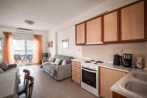 a kitchen and living room with a couch and a stove at Sunset's Nest by Golden Host in Flogita