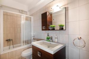 a bathroom with a sink and a toilet and a mirror at Sunset's Nest by Golden Host in Flogita +9 photos