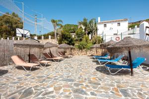 un gruppo di sedie e ombrelloni su una spiaggia di La Casa Grande a Málaga