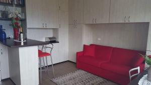 een woonkamer met een rode bank en een keuken bij Apartment Imma in Tremosine Sul Garda