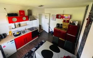 a small kitchen with red cabinets and a sink at Nordsee in Wilhelmshaven