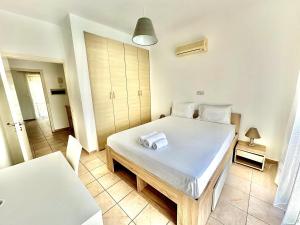une chambre avec un lit avec deux serviettes dessus dans l'établissement Cydonia Gardens Maisonette with shared pool, à Limassol 32 autres photos