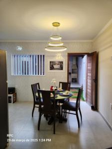a dining room with a table and chairs and a chandelier at Casa Nova Temporada Barreirinhas Lençóis Maranhense in Barreirinhas