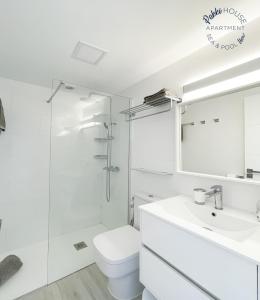 a white bathroom with a toilet and a sink at PAKKI house in Corralejo