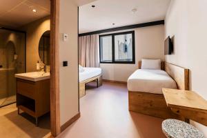 a bedroom with a bed and a sink and a mirror at easyHotel Madrid Alcala in Madrid