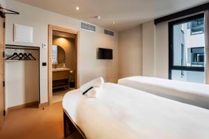 a hotel room with two beds and a mirror at easyHotel Madrid Alcala in Madrid