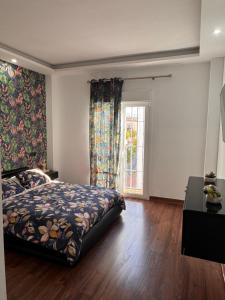 un dormitorio con una cama y una ventana en Selva House Sevilla, en Coria del Río