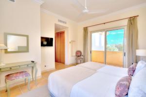 Un dormitorio con una cama y un escritorio y una ventana. en Monte Rei 2 bed linked villa, en Vila Nova de Cacela 35 fotos más