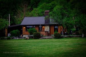 a house with a green lawn in front of it at House Arupium - HOT TUB in Otočac