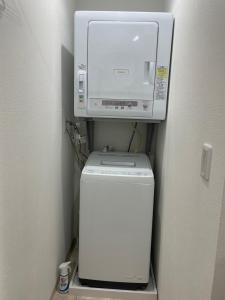 una lavatrice posizionata sopra una lavatrice e un'asciugatrice di Villa Hayabusa ad Osaka