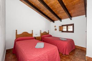 2 posti letto in una camera con lenzuola rosse di La Cuadra a Málaga