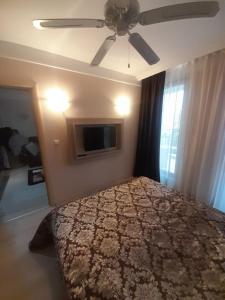 a bedroom with a bed and a ceiling fan at Nice 2 Room Apartment Harmony Suites 3 Sunnybeach in Sunny Beach