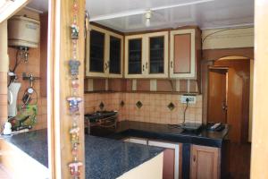 a kitchen with wooden cabinets and black counter tops at Nani House The mall road in Shimla