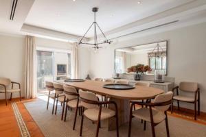 a dining room with a large wooden table and chairs at Villa Mayfair - Quinta do Lago in Almancil