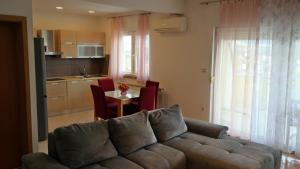 a living room with a couch and a table and a kitchen at Apartment Sarah in Čavle