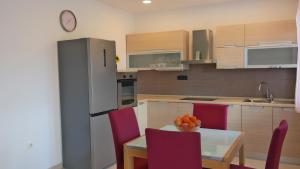 a kitchen with a table and chairs and a refrigerator at Apartment Sarah in Čavle