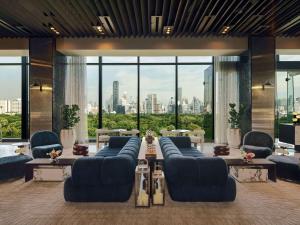 a lobby with blue couches and a view of a city at SO/ Bangkok in Bangkok