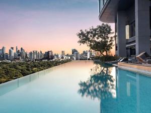 a swimming pool with a city skyline in the background at SO/ Bangkok in Bangkok