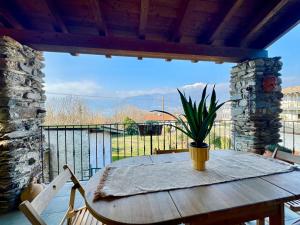 a wooden table with a potted plant on a balcony at Perla del Lago in Colico