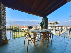 a patio with a table and chairs on a balcony at Perla del Lago in Colico