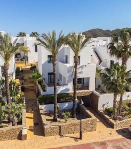 an aerial view of a building with palm trees at Villa de 4 dormitorios en el Resort Playa Macenas in Mojácar