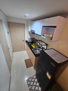 a small kitchen with a sink and a refrigerator at SMDC Field REsidences condo unit in Manila