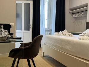 a bedroom with a bed and a chair and a desk at Amelié Lago d’Orta Hotel in Omegna