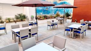 a restaurant with tables and chairs and umbrellas at LEVEL Mallorca - Living in Playa de Palma