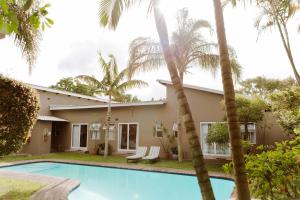 a villa with a swimming pool and palm trees at iGwalagwala Guest House in St Lucia