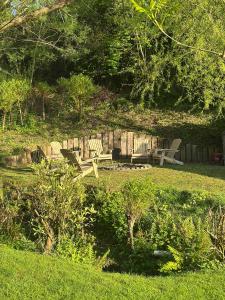 two park benches sitting in a field of grass at *New* Tranquil Countryside Luxury Barn Conversion in Georgeham +45 photos