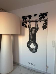 a monkey hanging from a tree mural on a wall at Villa Paradies in Klosterneuburg