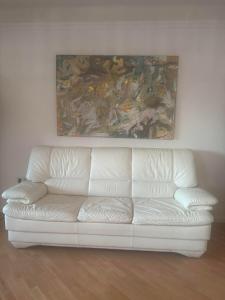a white couch in a room with a painting on the wall at Villa Paradies in Klosterneuburg