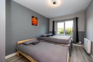 two beds in a room with a window at Cosy 2-Bedroom Apartment near Airport in Dublin