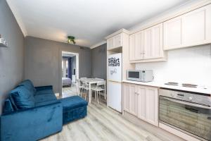 a living room with a blue couch in a kitchen at Cosy 2-Bedroom Apartment near Airport in Dublin