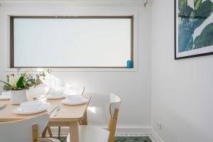 una sala da pranzo con tavolo, sedie e una finestra di Tranquil Retreat in Roseville With Garden Oasis a Sydney