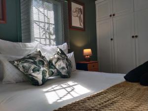 ein Schlafzimmer mit einem Bett mit Kissen und einem Fenster in der Unterkunft The Hilton Cottage in Hilton
