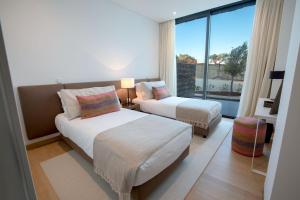 una camera da letto con due letti e una grande finestra di Monte Rei 1 bed apt a Vila Nova de Cacela Altre 24 foto