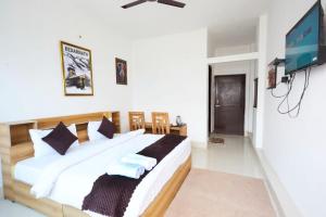 Postel nebo postele na pokoji v ubytování LA Riqueza Sushanti Retreat - Mountain View Rooms with Balcony # Pure Veg Restaurant # Jain Food Available # Parking # Customer's choice Hotel